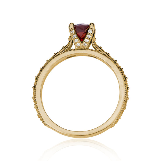 Profile view of the Victorian Mozambique Garnet solitaire with diamond and milgrain detailed band on white background.