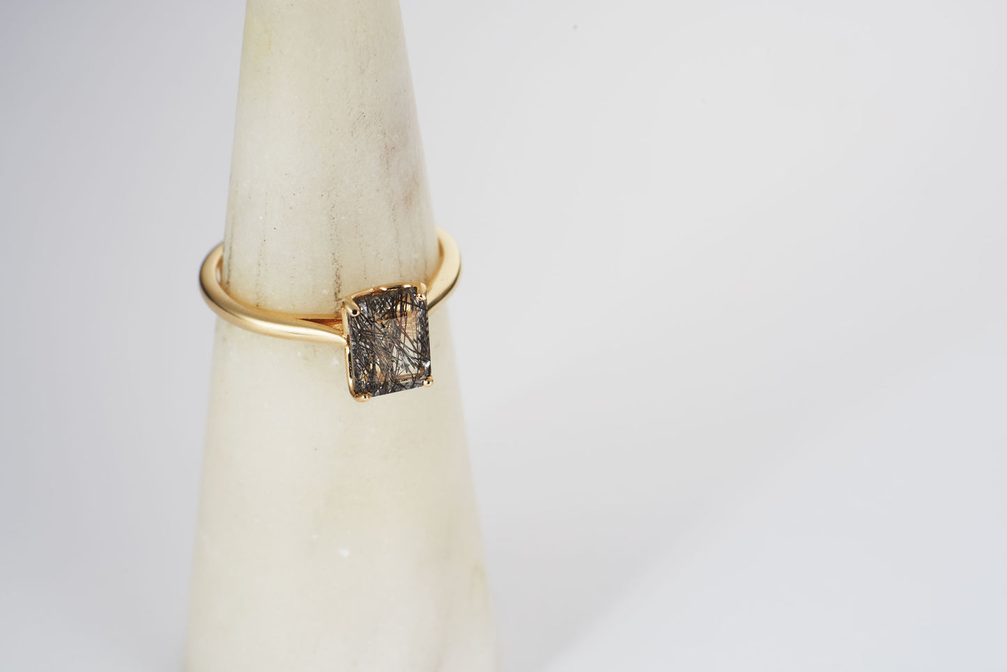 Close up view of the Nico rutile quartz solitaire ring on a ring cone.