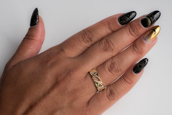Load image into Gallery viewer, A model&amp;#39;s hand wearing yellow gold cigar band with black and white diamonds
