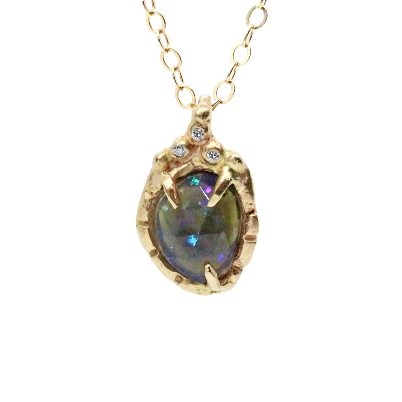 gold chain holding a black opal in 4 prongs, surrounded by free form diamonds pictured on white background 